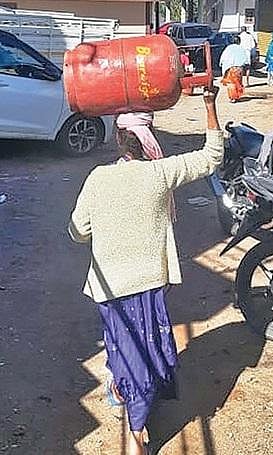 குன்னூரில் சிலிண்டர் பெற விநியோக வாகனம் அருகே வரிசையில் காத்திருந்த மக்கள்.
