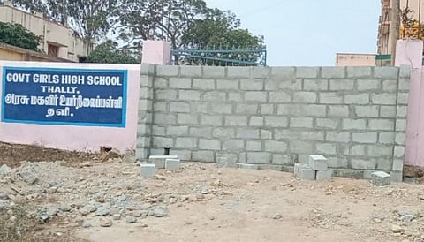 தளி அரசு மகளிர் உயர்நிலைப் பள்ளிக்குச் செல்லும் பாதை காவல் துறைக்கு சொந்தமான இடம் என்பதால் திடீரென கட்டப்பட்ட தடுப்புச் சுவர்.
