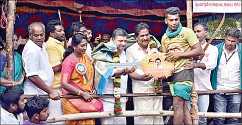 அவனியாபுரம் ஜல்லிக்கட்டில் அதிக காளைகளை அடக்கி முதலிடம் பிடித்த மாடுபிடி வீரர் கார்த்திக்கு காரை பரிசாக வழங்கிய அமைச்சர்கள் பி.மூர்த்தி, பழனிவேல் தியாகராஜன். உடன் மதுரை ஆட்சியர் சங்கீதா உள்ளிட்டோர்.  படம்: எஸ் கிருஷ்ணமூர்த்தி