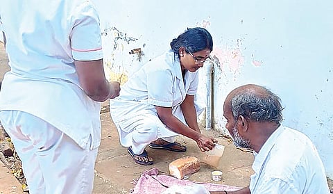 முதியவருக்கு உதவி செய்த செவிலியர்.