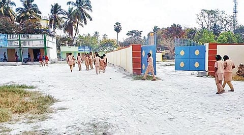 பர்கூர் அரசு மகளிர் மேல்நிலைப் பள்ளி வளாகத்தில் மழைநீர் தேங்காமல் இருக்க கொட்டப்பட்டுள்ள கிரானைட் கழிவால்,  சிரமத்துடன் நடந்து செல்லும் மாணவிகள்.