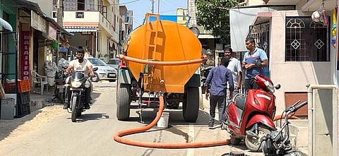 ஓசூர் மாநகராட்சி பாரதிதாசன் நகரில் டிராக்டரில் தண்ணீர் கொண்டுவந்து வீ்ட்டில் தண்ணீரை நிரம்புகின்றனர்.
