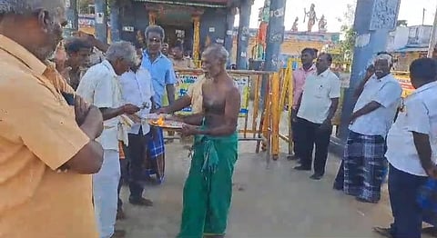 மேல்பாதி கோயிலில் காலை பூஜை நடத்திய பூசாரி பொது மக்களுக்கு தீபாரதனை காட்டுகிறார்