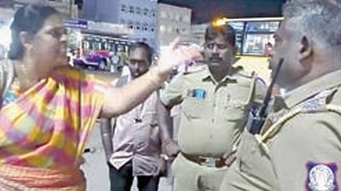 கரூர் பேருந்து நிலையத்தில் போலீஸாருடன் ஆவேசமாக பேசும் பெண்.