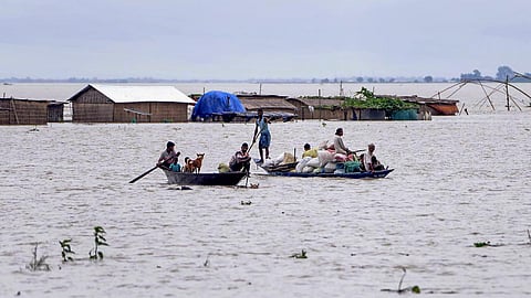 வெள்ள நீரில் படகில் பயணிக்கும் மக்கள்