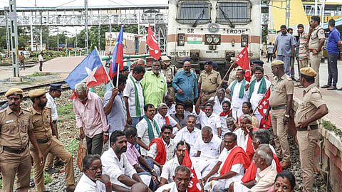 தண்டவாளத்தில் அமர்ந்து, ரயிலை மறித்து போராட்டத்தில் ஈடுபட்ட விவசாயிகள் சங்கத்தினர்.