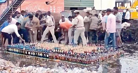 போலீஸாரை மீறி மதுபாட்டில்களை அள்ளிச் செல்லும் பொதுமக்கள்.