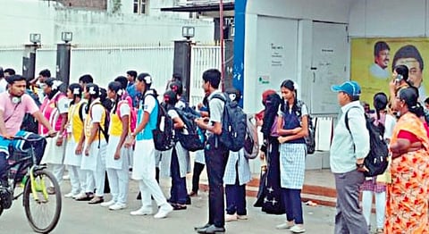மீஞ்சூர் பஜார் பகுதியில் உள்ள பேருந்து நிறுத்தத்தில் காத்திருக்கும் பொதுமக்கள், பள்ளி மாணவ-மாணவிகள்.