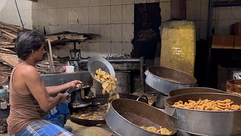 தீபாவளிப் பண்டிகையை முன்னிட்டு, காரமடை அருகே கை முறுக்கு தயாரிப்புப் பணியில் ஈடுபட்டுள்ள தொழிலாளர்கள்.  