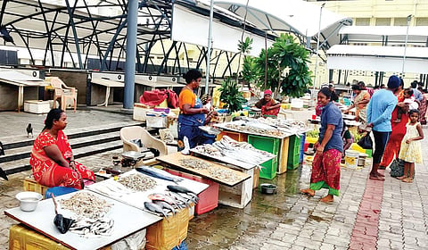 மெரினா வளைவு சாலை​யில் திறந்​தவெளி​யில்​ ​விற்​பனை​யில்​ ஈடு​பட்​டுள்​ள ​
மீன் வி​யாபாரி​கள்​. | படம்​: ச.​கார்​த்​திகேயன்​ |