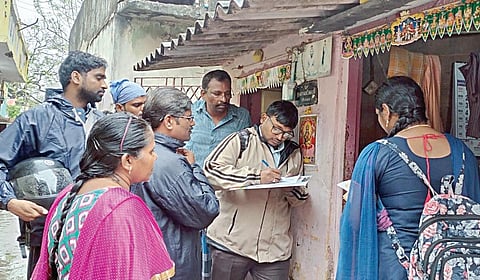 சென்னை பட்டினப்பாக்கத்தில் உள்ள நகர்ப்புற வாழ்விட மேம்பாட்டு வாரிய குடியிருப்பு பகுதியில் பயனாளிகள் குறித்து கணக்கெடுக்கும் அதிகாரிகள். | படம்: ம.பிரபு |