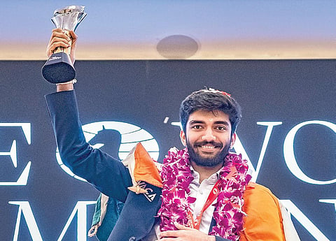 உலக செஸ் சாம்பியன்ஷிப் போட்டியில் சாம்பியன் பட்டம் வென்ற இந்திய கிராண்ட் மாஸ்டர் குகேஷ், டிராபியுடன்.படம்: பிடிஐ