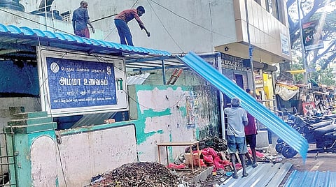 சென்னை வியாசர்பாடி, எம்கேபி நகரில் அம்மா உணவகக் கூரையில் புதிய இரும்பு தகடுகள் அமைக்கப்பட்டு வருகின்றன. | படம்: ச.கார்த்திகேயன் |