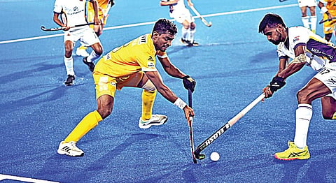 ஹாக்கி இந்தியா லீக்கில் தமிழ்நாடு டிராகன்ஸ் வீரர் உத்தம் சிங்கிடம் இருந்து பந்தை பறிக்க முயற்சி செய்கிறார் ஹைதராபாத் டூஃபேன்ஸ் வீரர்.