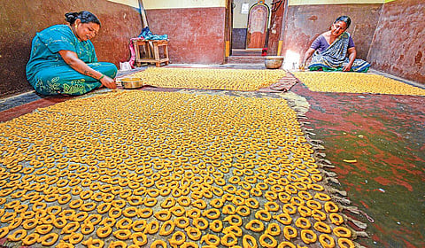 தஞ்சாவூர் அருகே புன்னைநல்லூர் மாரியம்மன் கோயிலைச் சுற்றியுள்ள தெருக்களில் உள்ள வீடுகளில் மட்டுமே குடிசைத் தொழிலாக பெண்கள் குச்சி முறுக்கு செய்யும் பணியில் குடும்பத்துடன் ஈடுபட்டுள்ளனர். | படங்கள்: ஆர்.வெங்கடேஷ் |