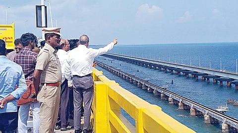 பாம்பன் சாலை பாலத்திலிருந்து புதிய ரயில் பாலத்தை பார்வையிட்ட தெற்கு ரயில்வே கூடுதல் பொது மேலாளர் கவுசல் கிஷோர். உடன், மதுரை கோட்ட மேலாளர் சரத் வஸ்தவா உள்ளிட்டோர்.