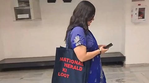 நேஷனல் ஹெரால்ட் கொள்ளை வாசகம் எழுதப்பட்ட பையுடன் வந்த பாஜக எம்.பி.
