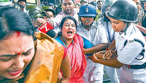 கொல்கத்தாவில் சட்டக் கல்லூரி மாணவிக்கு பாலியல் வன்கொடுமையை கண்டித்து பாஜக சார்பில் நேற்று நடைபெற்ற போராட்டத்தில் ஈடுபட்ட பெண் நிர்வாகியை போலீஸார் கைது செய்தனர். படம்: பிடிஐ