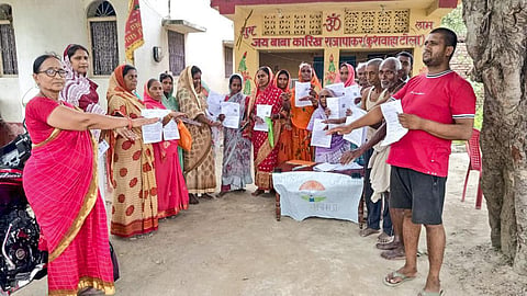 பிஹார் மாநிலம் வைஷாலி மாவட்டத்தில் வாக்காளர் திருத்த படிவங்களுடன் நிற்கும் மக்கள்.
