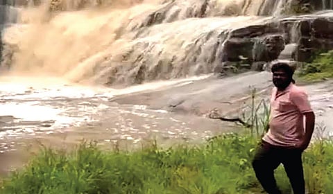 கொடைக்கானல் ஓராவி அருவியில் வெள்ளப்பெருக்கு ஏற்பட்டபோது ஆபத்தான முறையில் நின்று புகைப்படம் எடுத்த பரத்.
