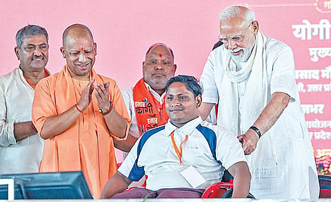 உத்தர பிரதேசத்தின் வாராணசியில் நேற்று நடைபெற்ற நலத்திட்ட விழாவில் மாற்றுத் திறனாளி ஒருவருக்கு பிரதமர் மோடி சக்கர நாற்காலி வழங்கினார். உடன் உத்தர பிரதேச முதல்வர் யோகி ஆதித்யநாத் உள்ளார்.