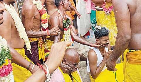 மேட்டு மகாதானபுரம் மகாலட்சுமி அம்மன் கோயிலில் பக்தரின் தலையில்
தேங்காய் உடைத்த கோயில் பூசாரி. | படம்: க.ராதாகிருஷ்ணன் |