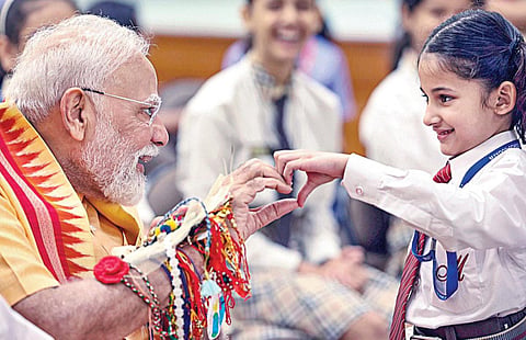டெல்லியில் பிரதமர் நரேந்திர மோடியின் இல்லத்தில் நடைபெற்ற ரக்‌ஷா பந்தன் நிகழ்ச்சியில் அவருக்கு பள்ளிக் குழந்தைகள் ராக்கி கயிறு கட்டினர். பின்னர் பள்ளி குழந்தைகளுடன் அவர் கலந்துரையாடினார். படம்: பிடிஐ