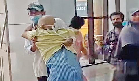 கோவை அரசு மருத்துவமனையில் சக்கர நாற்காலி வழங்காததால் உடல்நலம் பாதிக்கப்பட்ட தனது தந்தையை சிரமத்துடன் தூக்கிச் சென்ற காளிதாஸ்.
