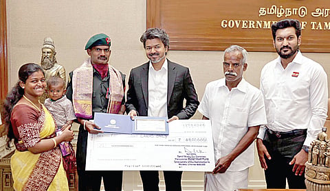 வீர தீரச் செயலுக்காக ‘கீர்த்தி சக்ரா’ விருது பெற்ற ராணுவ வீரர் மீனாட்சி சுந்தரத்துக்கு முதல்வர் விஜய் ரூ.48 லட்சத்துக்கான காசோலையை வழங்கிப் பாராட்டினார். உடன் படைவீரர் நலத் துறை அமைச்சர் சரத்குமார், ராணுவ வீரரின் குடும்பத்தினர்.