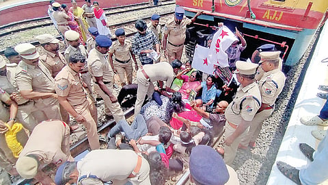 திருப்பரங்குன்றத்தில் தண்டவாளத்தில் படுத்துக்கொண்டு  ரயிலை மறித்த போராட்டக்காரர்களை அப்புறப்படுத்திய  போலீஸார். | படம்: நா.தங்கரத்தினம் |