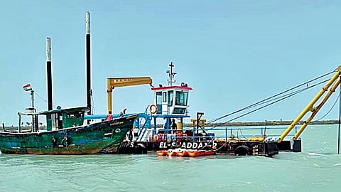 பாம்பன் கடல் கால்வாயில் கப்பல்கள், விசைப்படகுகள் தடையின்றி செல்ல தூர்வாரும் பணியில் ஈடுபட்டுள்ள கப்பல்.