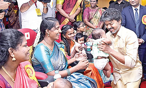 மதுரை அரசு ராஜாஜி மருத்துவமனையில் நேற்று நடைபெற்ற விழாவில் ஒரு குழந்தைக்கு தங்க மோதிரம் அணிவித்து, ‘தாய்மாமன் தங்க மோதிரம்’ திட்டத்தை முதல்வர் விஜய் தொடங்கி வைத்தார். விழாவில் பங்கேற்ற தாய்மார்களின் குழந்தையைத் தூக்கிக் கொஞ்சி மகிழ்ந்த முதல்வர் விஜய்.