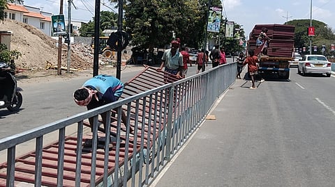 முதல்வர் விஜய் வருகையையொட்டி, கோவை விமான நிலைய சாலையில் கட்சி தொண்டர்கள், பொதுமக்கள் பாதுகாப்பாக நின்று வரவேற்பு அளிக்க தடுப்புக் கம்பிகளை அமைக்கும் பணியில் ஈடுபட்டுள்ள தொழிலாளர்கள். 