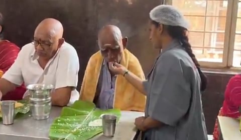 கைகள் இல்லாத மாற்றுத்திறனாளி பக்தருக்கு உணவை ஊட்டி விட்ட தேவஸ்தான ஊழியர்: குவியும் பாராட்டு