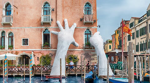 A sculpture installation by Lorenzo Quinn titled "Building Bridges," which was displayed at the Venice Biennale