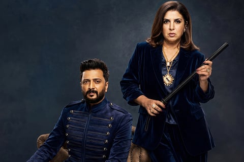 Riteish Deshmukh and Farah Khan posing in deep blue velvet outfits as jailers for their Netflix captive reality show Lock Upp: Sach ya Sazaa.