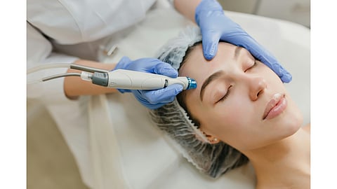Woman receiving an energy-based facial treatment to improve skin firmness