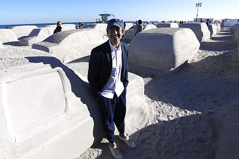 Artist Leandro Erlich of Argentina and his sand sculpture of a traffic jam titled, Order of Importance, at Miami Art Week. The work was commissioned by the city of Miami Beach. (AP Photo/Lynne Sladky)