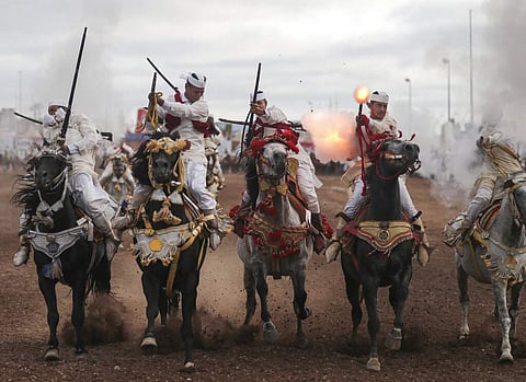 A troupe charges firing their rifles during Tabourida, a traditional horse riding show also known as Fantasia, in the coastal town of El Jadida, Morocco. (AP Photo/Mosa'ab Elshamy)