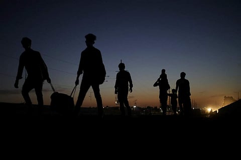 New Delhi: A migrant labourer's family is silhouetted as they proceed towards their village on foot. India is witnessing an exodus unlike anything since the 1947 Partition. (AP Photo/Altaf Qadri)