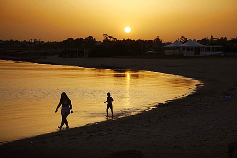 Beachgoers at sunset at an empty stretch of Dome beach hotel at Makrinissos in Cyprus' seaside resort of Ayia Napa. (AP Photo/Petros Karadjias)