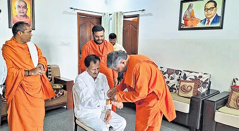ವಾಲ್ಮೀಕಿ ಗುರುಪೀಠದ ಶ್ರೀ ಪ್ರಸನ್ನಾನಂದ ಸ್ವಾಮೀಜಿಗಳು ತುಮಕೂರು ಲೋಕಸಭಾ ಅಭ್ಯರ್ಥಿ ಎಸ್‌ಪಿ ಮುದ್ದಹನುಮೇಗೌಡ ಅವರ ಮಣಿಕಟ್ಟಿಗೆ ರಕ್ಷೆ ದಾರವನ್ನು ಕಟ್ಟಿದರು.