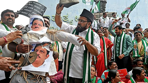 JD(S) leaders and workers protest against Minister B Z Zameer Ahmed Khan for his alleged racist remarks on Union Minister H D Kumaraswamy at Freedom Park, in Bengaluru on Wednesday.