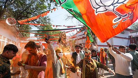 BJP supporters celebrate the party's decisive lead in the Delhi Assembly polls as counting of votes is underway, outside the Delhi BJP office.