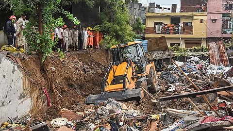 Debris being removed from the site after a wall collapsed 