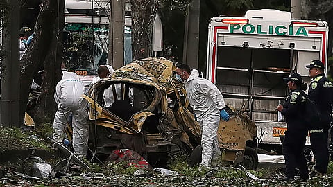 Security forces inspect the site of a bomb explosion outside an Air Force base in Cali, Colombia, Thursday, Aug. 21, 2025. 