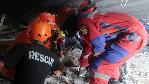 Rescuers pull out a survivor from a collapsed building at an Islamic boarding school in Sidoarjo, East Java, Indonesia