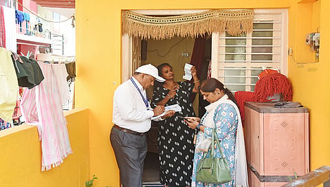 An enumerators collects details from a family as part of the socio-economic survey 
