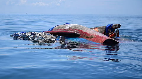 A capsized boat carrying Rohingya refugees drifts in the Andaman Sea