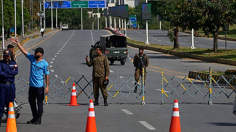 Police officers stand guard at a checkpoint ahead of the second round of negotiations between the US and Iran, in Islamabad, April 21, 2026.